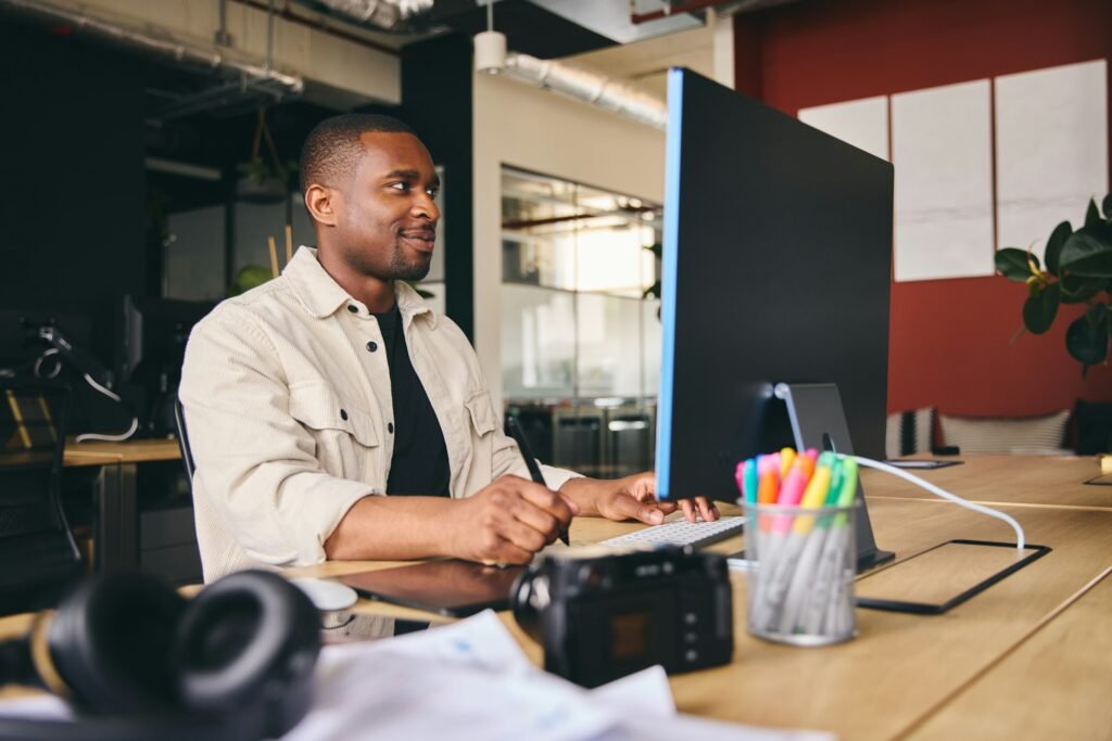 Male Advertising Marketing Or Design Creative In Office Sitting At Desk